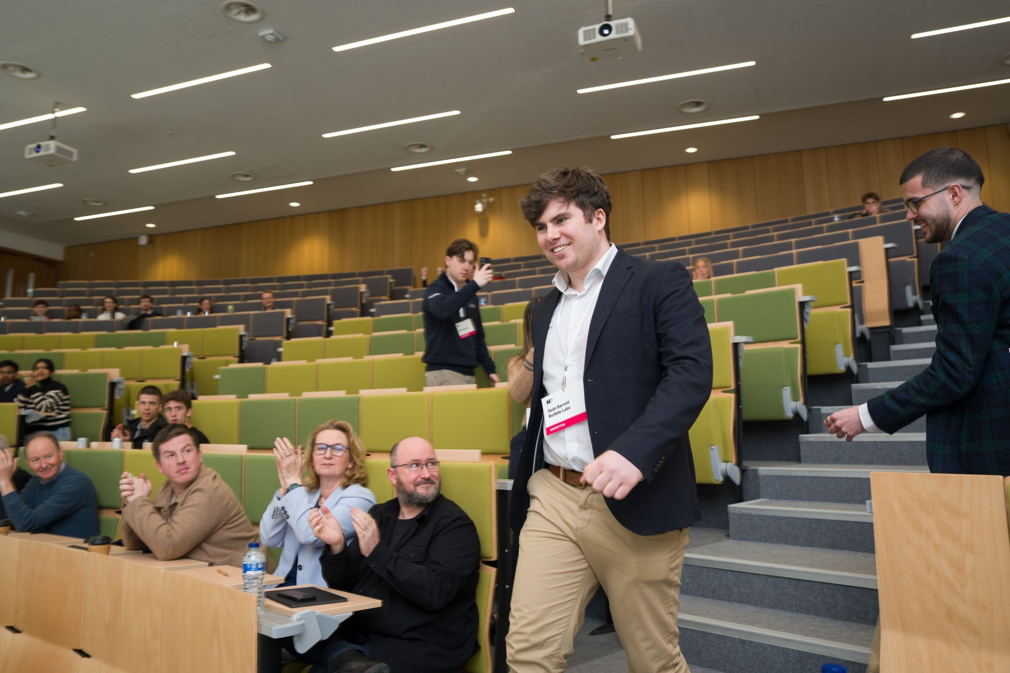 Sean Barrett walking through an applauding audience at the Hult Prize Irish National Final